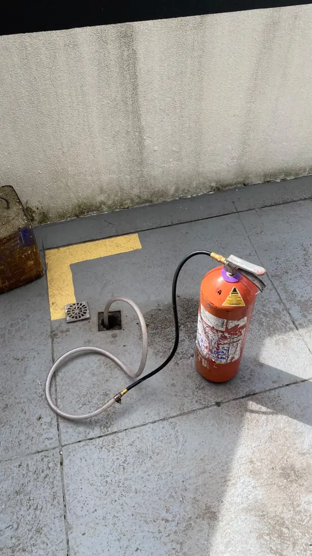 Pulverizador da D.Lucca pronto para aplicação em terraço junto a um ralo